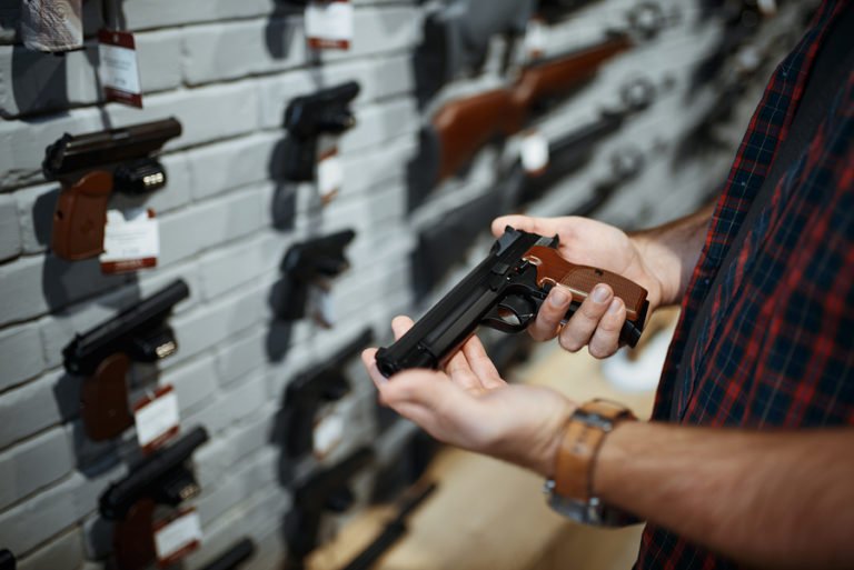 Man holds handgun in gun shop