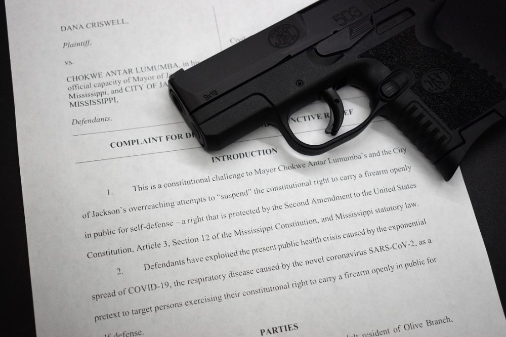 A lawsuit over the right to keep and bear arms with an FN 503 pistol on top 
