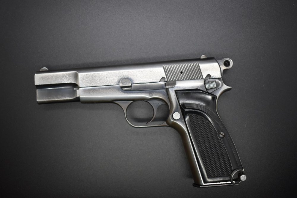 A Browning Hi-Power pistol with a distressed finish